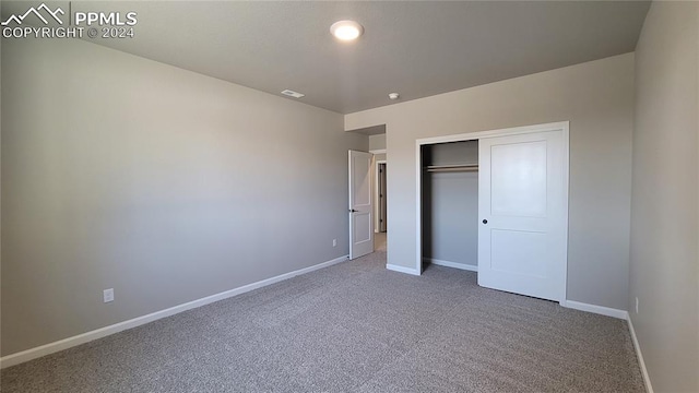 unfurnished bedroom with a closet and carpet flooring