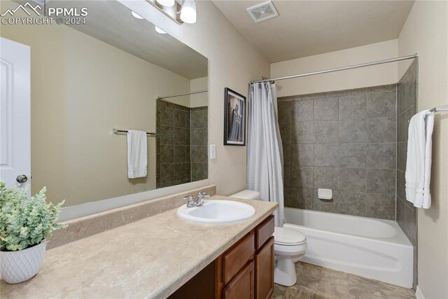 full bathroom with vanity, shower / bath combo with shower curtain, and toilet