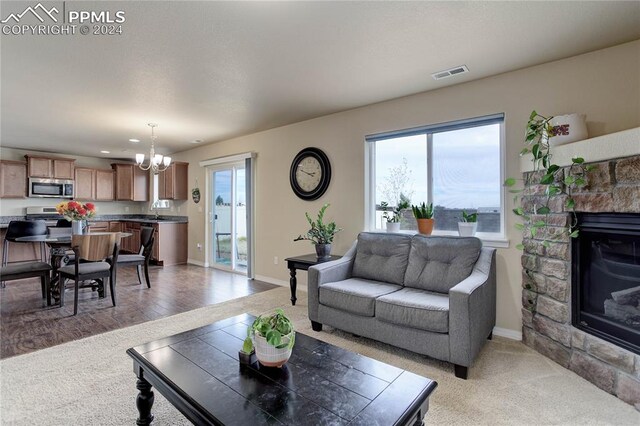 living room featuring light hardwood / wood-style floors, an inviting chandelier, sink, and a fireplace