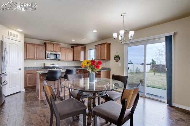 dining space featuring dark hardwood / wood-style flooring and a chandelier