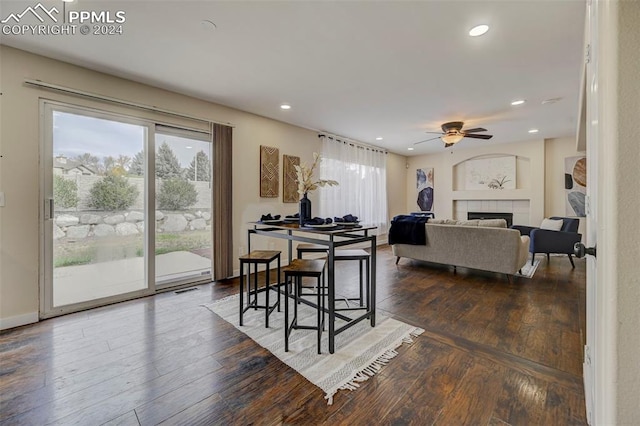 dining room featuring ceiling fan, dark hardwood / wood-style flooring, and a fireplace