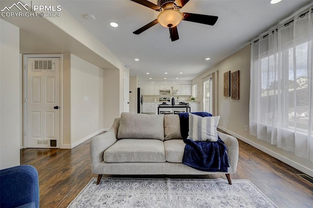 living room featuring wood-type flooring and ceiling fan