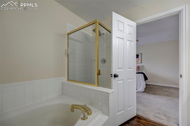 bathroom with hardwood / wood-style floors and shower with separate bathtub