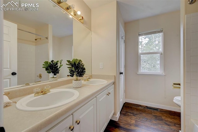 bathroom with vanity, a shower, wood-type flooring, and toilet