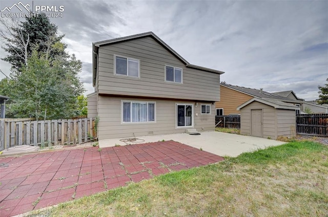 rear view of property with a storage unit, a yard, and a patio