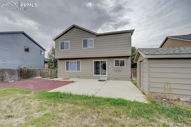 back of house with a patio area and a lawn