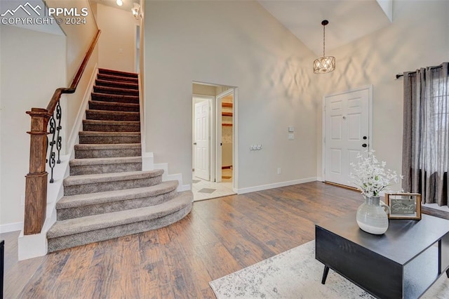 entrance foyer featuring a high ceiling, hardwood / wood-style flooring, and an inviting chandelier