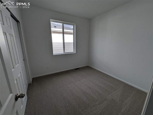 unfurnished bedroom with dark colored carpet