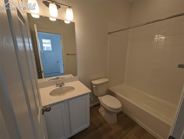 full bathroom featuring hardwood / wood-style floors, vanity, toilet, and tiled shower / bath