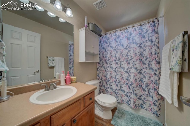 bathroom with a shower with shower curtain, vanity, toilet, and hardwood / wood-style flooring