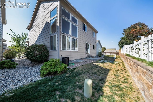 view of home's exterior with central AC and a lawn