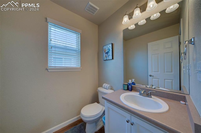 bathroom featuring vanity, toilet, and hardwood / wood-style flooring