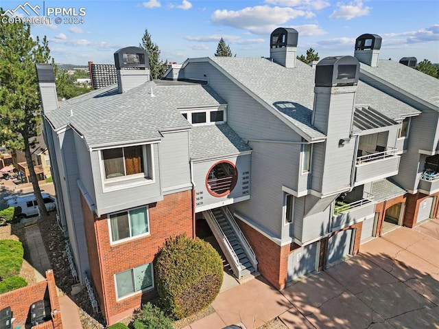 exterior space with ac unit, a balcony, and a garage