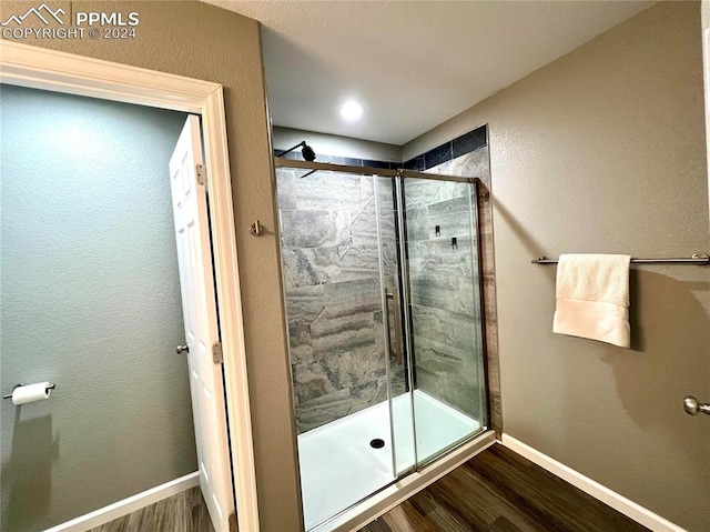 bathroom featuring hardwood / wood-style flooring and a shower with door