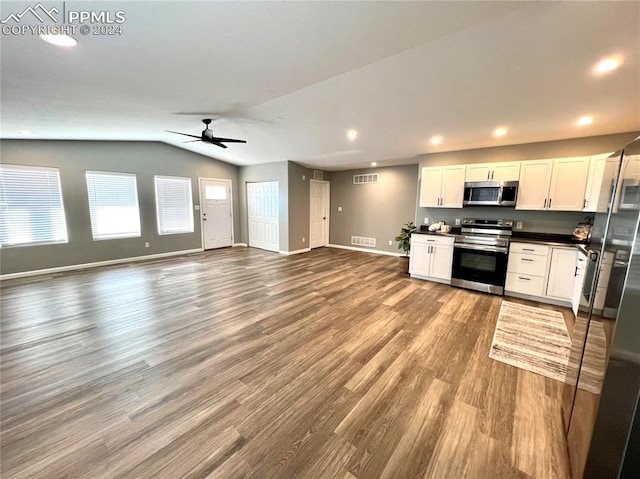 kitchen with lofted ceiling, ceiling fan, wood-type flooring, white cabinetry, and appliances with stainless steel finishes