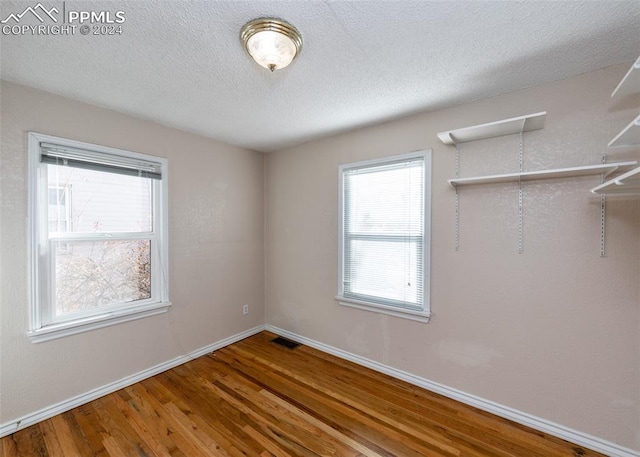 empty room featuring a textured ceiling and hardwood / wood-style flooring