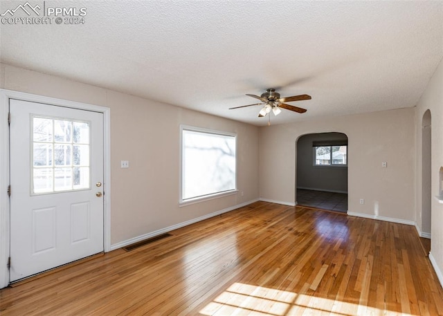 entrance foyer featuring hardwood / wood-style flooring, ceiling fan, and a textured ceiling