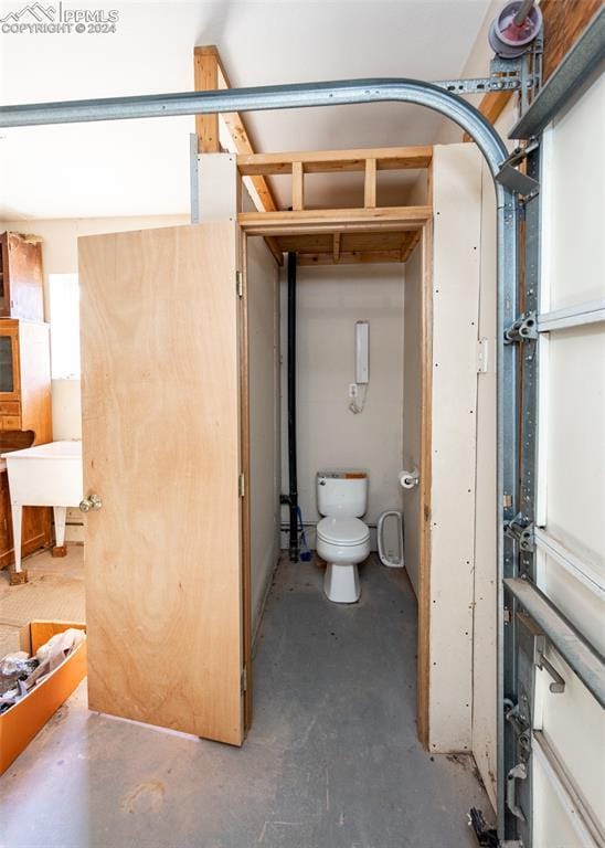 bathroom featuring concrete floors and toilet