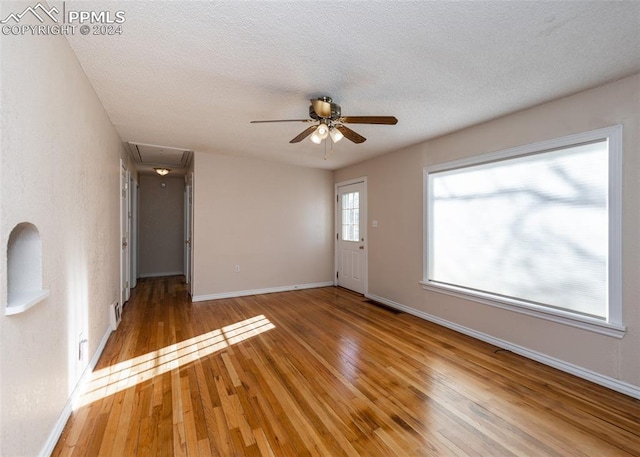 spare room with hardwood / wood-style floors, a textured ceiling, and ceiling fan