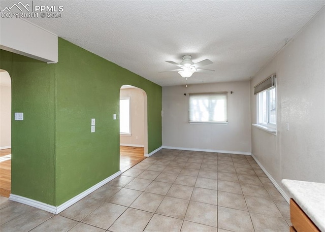 tiled spare room featuring ceiling fan and a textured ceiling