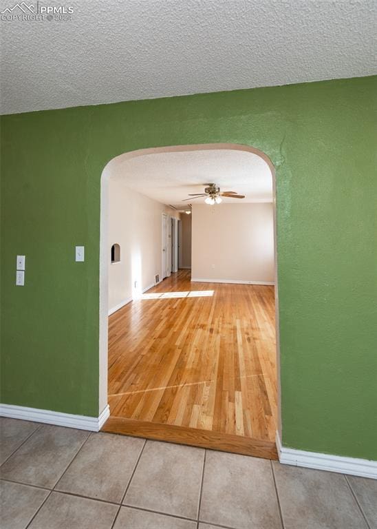 hallway featuring wood-type flooring and a textured ceiling