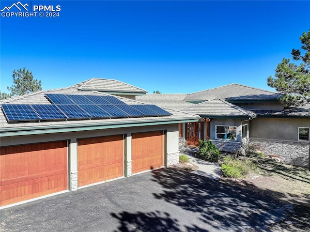 prairie-style home featuring solar panels and a garage