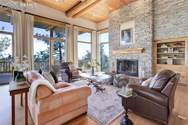 living room with a wealth of natural light, beamed ceiling, light hardwood / wood-style flooring, and wooden ceiling