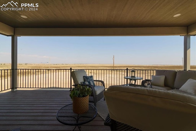 deck featuring an outdoor hangout area and a rural view