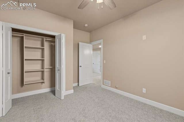 unfurnished bedroom featuring light carpet, ceiling fan, and a closet