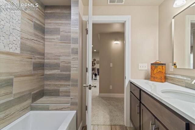 bathroom with vanity, hardwood / wood-style floors, and a bath