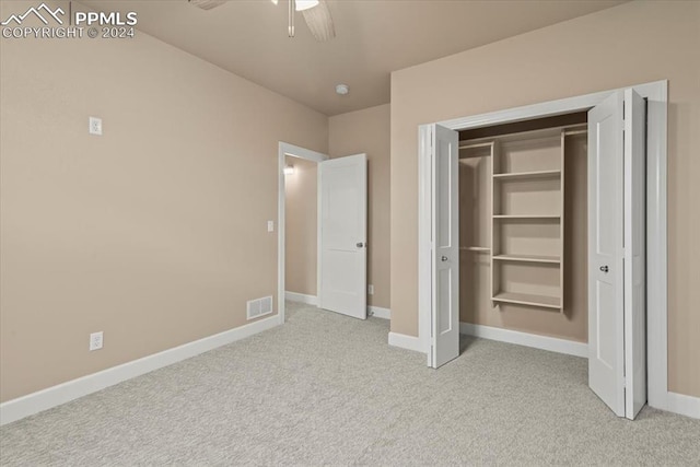 unfurnished bedroom featuring light carpet, a closet, and ceiling fan