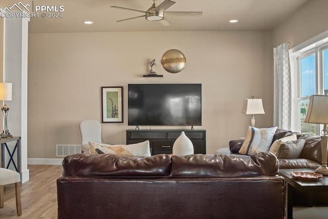 living room with ceiling fan and light hardwood / wood-style flooring