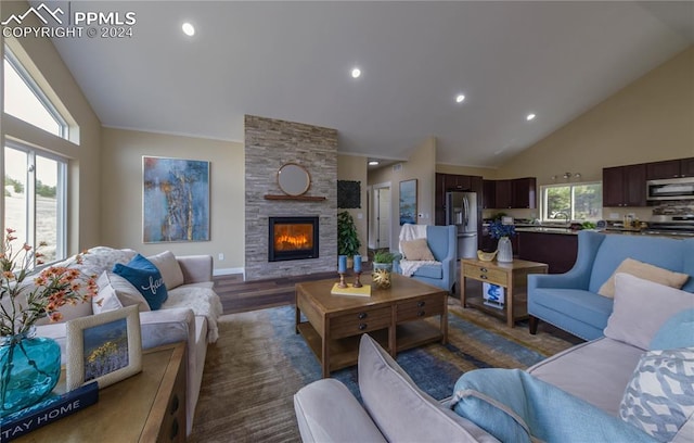 living room with high vaulted ceiling, a healthy amount of sunlight, a fireplace, and dark hardwood / wood-style floors