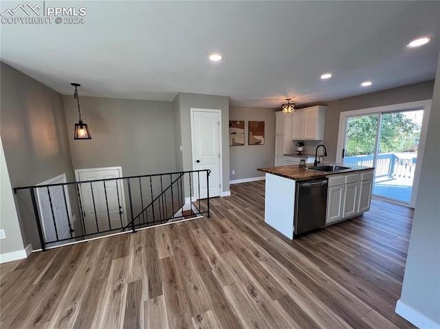 kitchen featuring white cabinets, sink, butcher block countertops, decorative light fixtures, and dishwasher