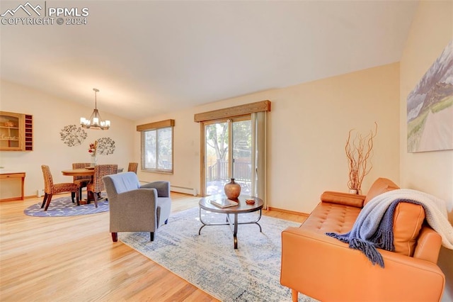 living room featuring lofted ceiling, hardwood / wood-style flooring, a baseboard heating unit, and a chandelier