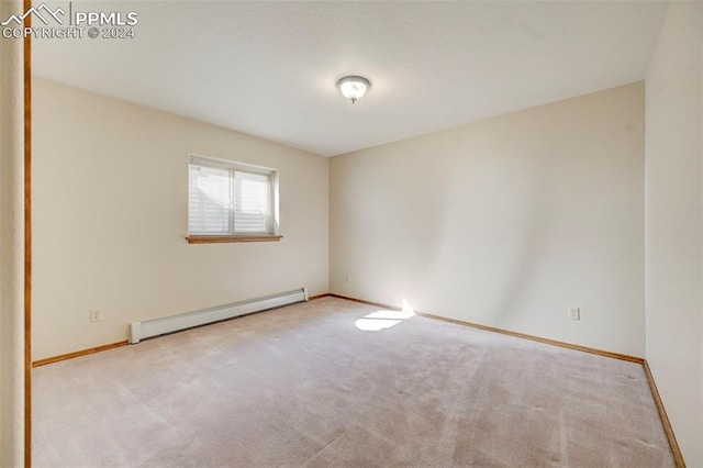 carpeted spare room featuring baseboard heating