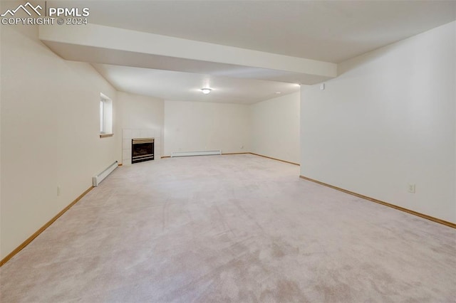 basement with light colored carpet, a baseboard radiator, and a tiled fireplace