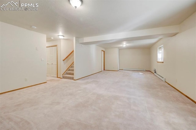 basement featuring light colored carpet and a baseboard radiator