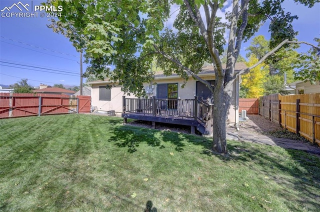 rear view of property with a yard and a deck