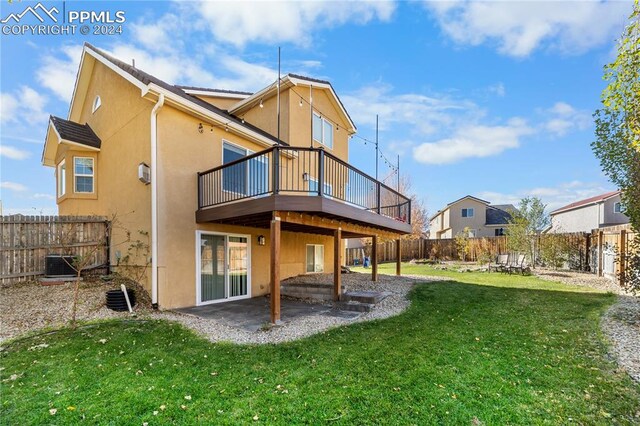 rear view of house with a wooden deck, a yard, a patio area, and central AC unit