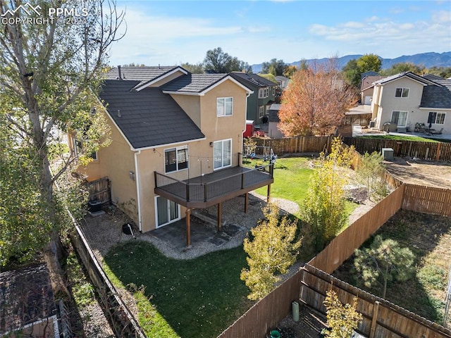 rear view of property with a mountain view and a yard