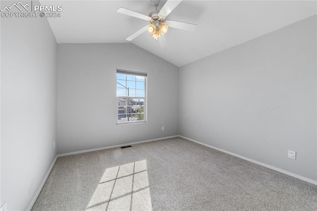 carpeted empty room featuring vaulted ceiling and ceiling fan