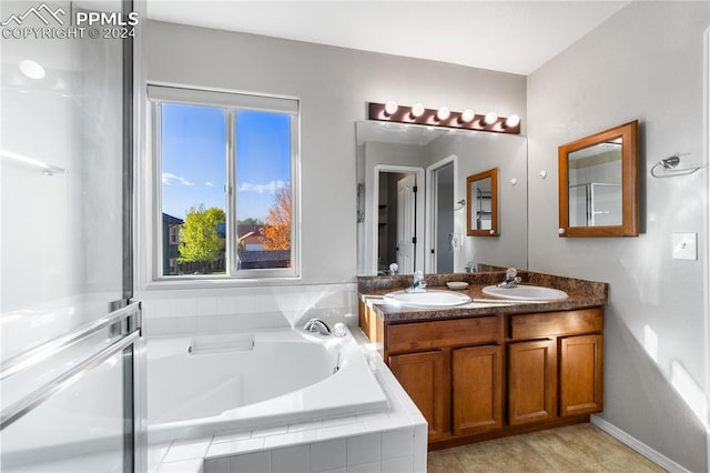 bathroom with vanity and a relaxing tiled tub