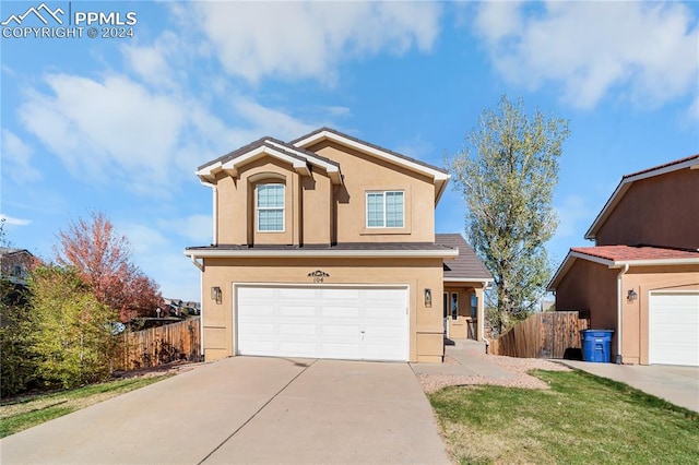 view of property featuring a front yard and a garage