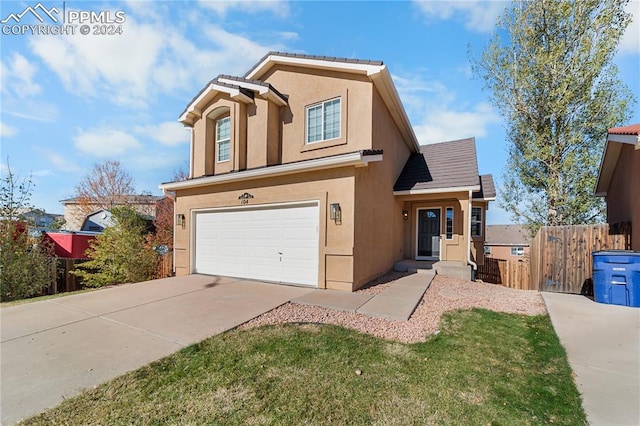 view of front of home with a front yard and a garage