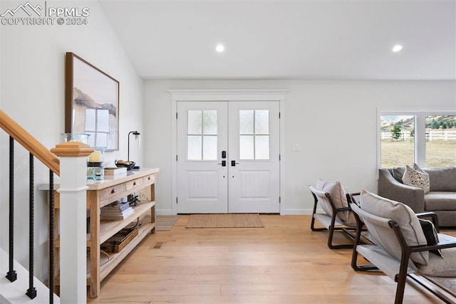 entrance foyer featuring french doors, vaulted ceiling, and light hardwood / wood-style flooring