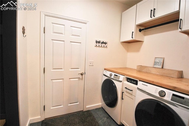 laundry area featuring washing machine and clothes dryer and cabinets