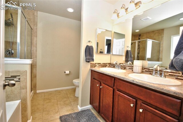 bathroom with tile patterned flooring, a shower with door, vanity, and toilet