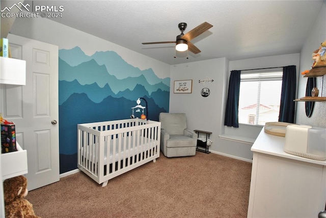 carpeted bedroom featuring a crib and ceiling fan