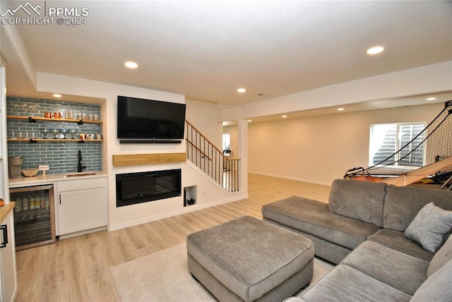 living room featuring wet bar, wine cooler, and light wood-type flooring